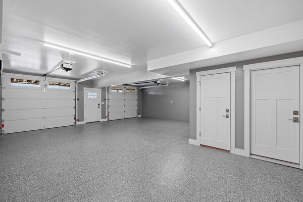 Modern two-car garage with epoxy floors, LED lighting, and automatic garage door opener