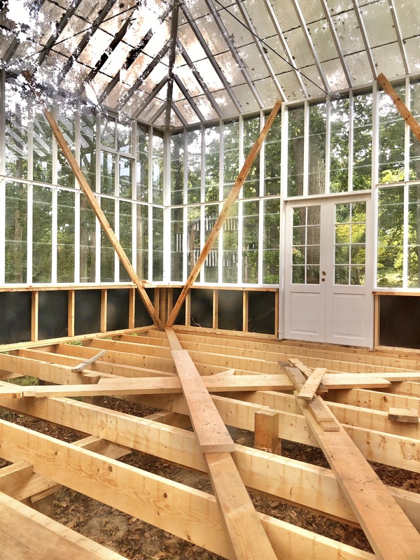 Timbertech composite wood decking frame under construction with clear glass walls and trex deck board layout.
