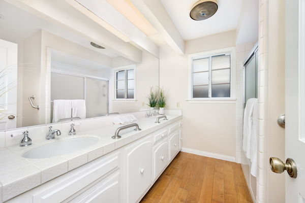 Classic White Bathroom With Double Sink Vanity Double sink bathroom vanity with white cabinets and tiled countertops ideal for bathroom remodeling near me