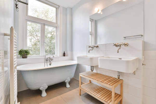 Bright and airy bathroom renovation with vintage bathtub, twin sinks, and modern fixing bathrooms style