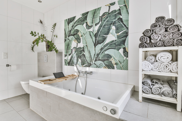 Modern bathroom remodeling help featuring spa bathtub, botanical wall art, and luxury bathroom renovation style