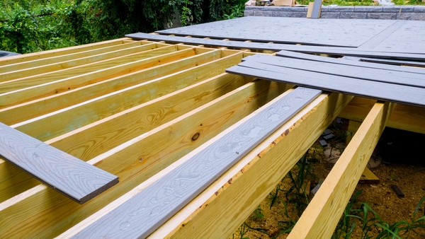 Installing Composite Deck Boards on Joists Composite deck boards being installed on wooden joists during deck construction