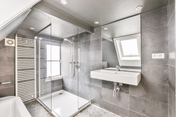 Gray-tiled bathroom with walk-in shower under sloped ceiling, a perfect designer tile bathroom and designing bathrooms ideas concept