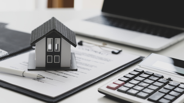 Pen and house model on real estate documents with laptop and calculator, highlighting financing through sofi rocket mortgage equity lending club.