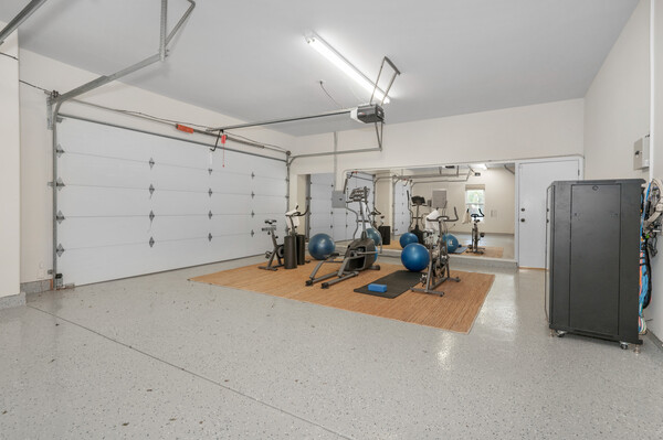 Converted garage space with gym equipment, home workout setup, and rubber mats
