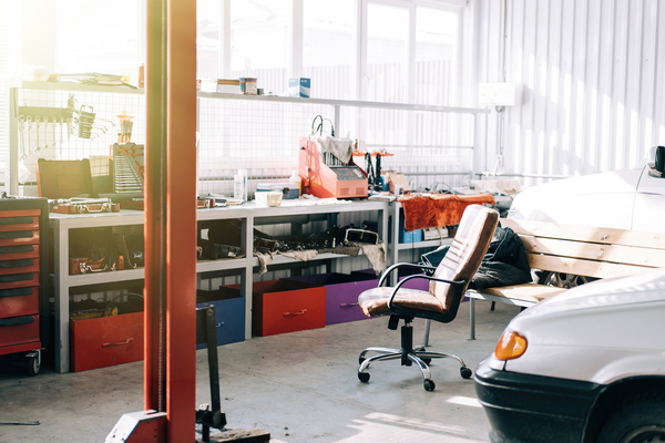 Auto repair garage setup with mechanic tools, garage door panels, and commercial garage door repair setup