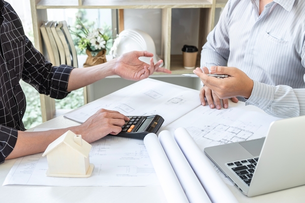 Two people discussing plans and calculator referencing home equity loans in sharpsburg nc