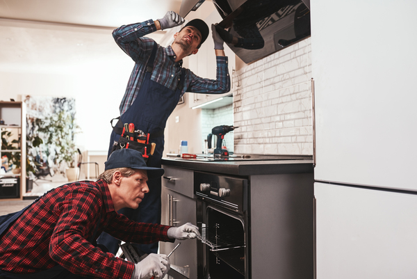 house repair and remodel – licensed and bonded contractors near me working on kitchen installation Two skilled workers completing house repair and remodel tasks, showing the value of licensed and bonded contractors near me