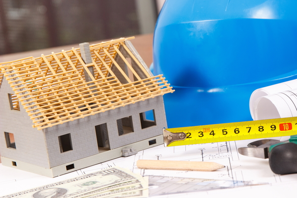 Construction model with tape measure and dollar bills illustrating hud roof replacement program and 185 000 stimulus for homeowners