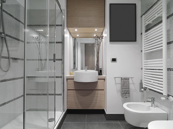 Small modern bathroom with glass shower, bidet, and natural wood cabinetry – master bathroom design 2023