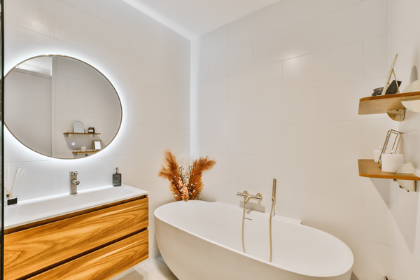 Clean bathroom decor ideas featuring freestanding tub, LED mirror, and wooden vanity