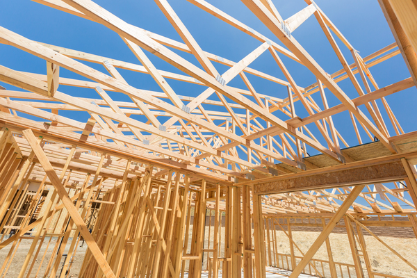 Wooden trusses on top of a house structure showing roof truss spacing and construction