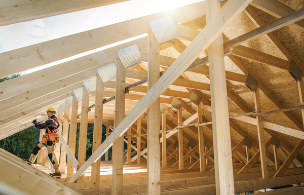 Builder installing roof trusses for a modern house showcasing roof framing and truss structure